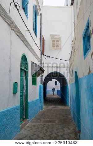 Narrow old street and gate in the medina of Asilah, Morocco