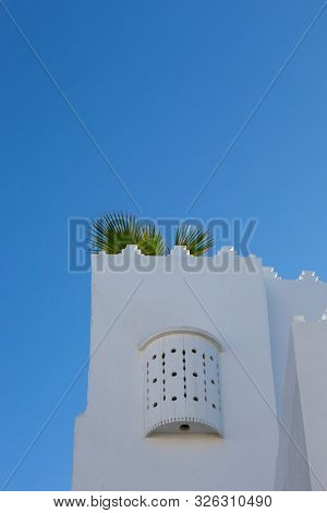 Moroccan white design window upstairs at a plasterd wall in Assilah, Morocco