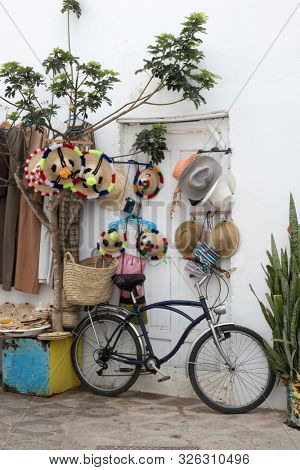 Bicycle standing in front of merchandise in the medina of Asilah, Northern Morocco