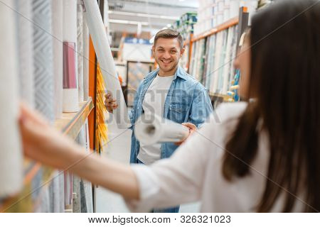 Young couple buying wallcovering in hardware store