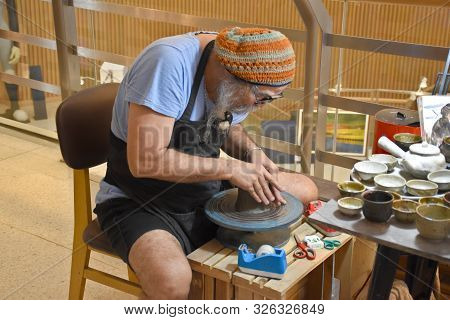 Bangkok, Thailand 08.23.2019: A Thai Artist Is Making A Clay Bowl Very Precisely At The Bangkok Art 
