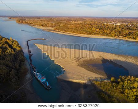 Cleaning and deepening by a dredger on the river. Ob river, Siberia, Russia
