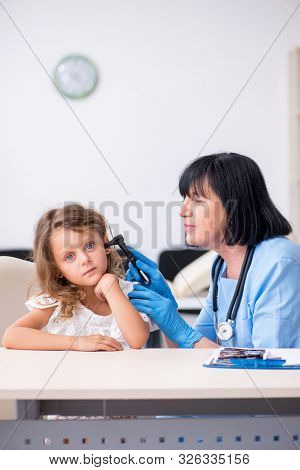 Little girl visiting old female doctor