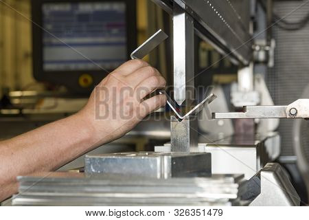 Worker Operating Metal Press Machine At Workshop. Bending Of Metal On The Machine.