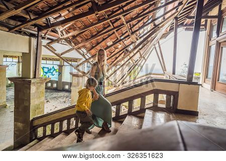 Mother And Son Tourists In Abandoned And Mysterious Hotel In Bedugul. Indonesia, Bali Island. Bali T