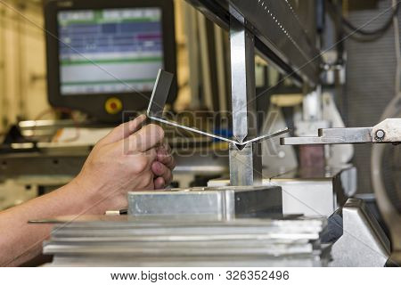 Worker Operating Metal Press Machine At Workshop. Bending Of Metal On The Machine.
