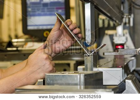 Worker Operating Metal Press Machine At Workshop. Bending Of Metal On The Machine.