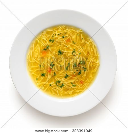 Instant Chicken Noodle Soup In A White Ceramic Soup Plate Isolated On White. Top View. Chopped Parsl