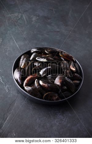 Bowl With Fresh Raw Mussels On Dark Background