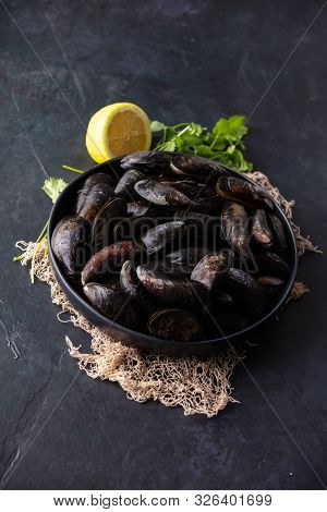 Bowl With Fresh Raw Mussels On Dark Background