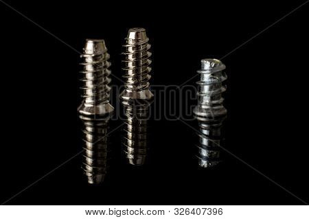 Group Of Three Whole Metallic Glossy Bolt Isolated On Black Glass