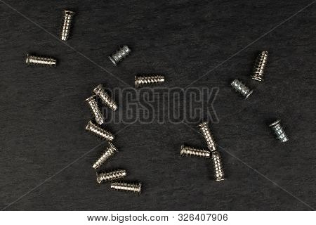 Group Of Sixteen Whole Metallic Glossy Bolt Flatlay On Grey Stone