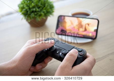 Anapa, Russia - October 2, 2019: Man Hand Holding Dualshock 4 Play Game Rayman Adventures In The Scr