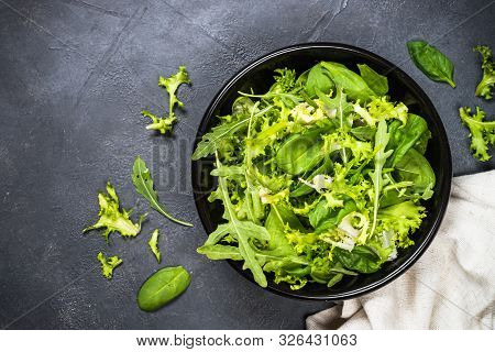 Green Salad Leaves Mix. Baby Spinach Leaves, Arugula And Frieze On Black Background. Top View With C