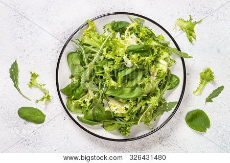 Green Salad Leaves Mix. Baby Spinach Leaves, Arugula And Frieze On White Stone Background. Top View 