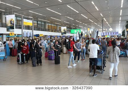 Amsterdam, Netherlands - July 11, 2017: Travelers Visit Schiphol Airport In Amsterdam. Schiphol Is T