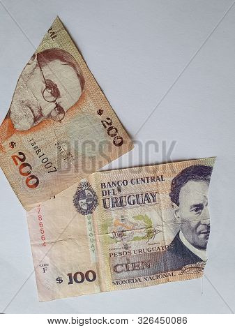 Uruguayan Banknotes Of Different Denominations On The Broken Sheet Of Paper