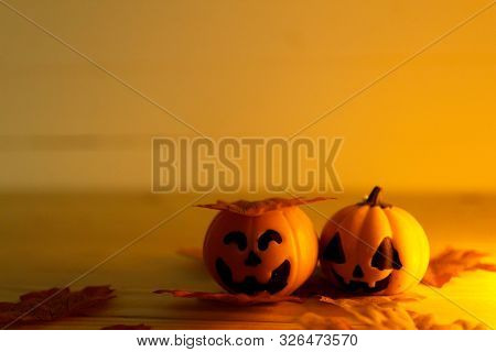 Halloween Pumpkins With Painted Faces On A Wooden Table. Halloween Background. Space For Text. Copy