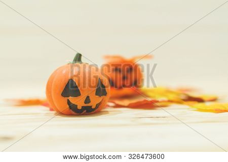 Halloween Pumpkins With Painted Faces On A Wooden Table. Halloween Background. Space For Text. Copy