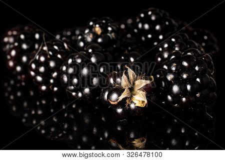 Lot Of Whole Fresh Black Blackberry Isolated On Black Glass