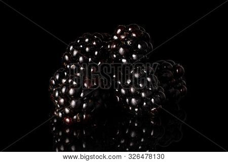 Group Of Five Whole Fresh Black Blackberry Isolated On Black Glass