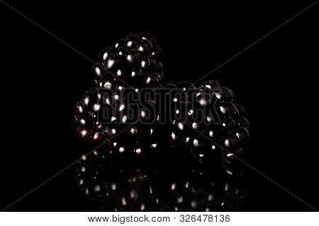 Group Of Three Whole Fresh Black Blackberry Isolated On Black Glass