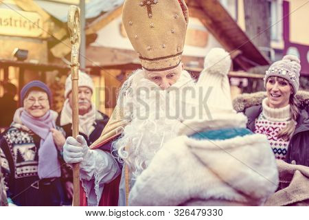 St Nicholas and an extended family with child on the Christmas market
