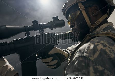 Close Up Of American Soldier Keeping Sight On Modern Gun Weapon, Looking At Side. Ranker Having Oper