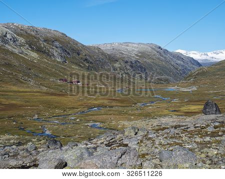 Autumn View On Red Krossbu Tourist Station Mountain Hut Buildings From Hike To Glacier Smorstabbreen