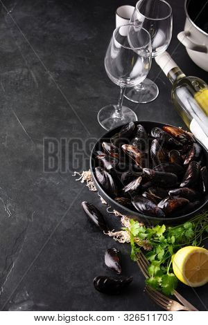 Bowl with fresh raw mussels with white wine, lemon and parsley