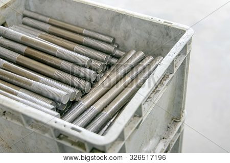 Large Number Of Metal Studs With Thread Randomly Lie In A Plastic Box, Close-up