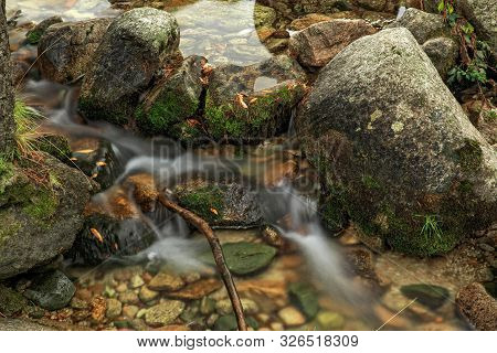 Rocks In A Small Stream At Sunset
