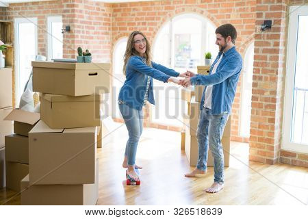 Young couple moving to a new home, having fun riding a skateboar