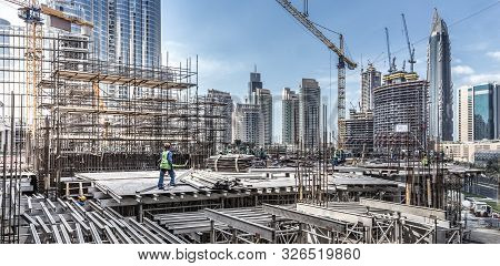 Laborers Working On Modern Constraction Site Works In Dubai. Fast Urban Development Consept