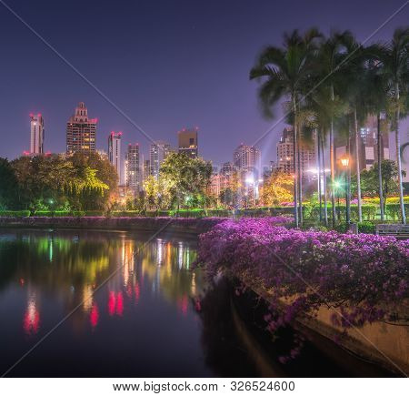 Lake With Calm Water Reflecting Nearby Buildings In South Part Of Benjakiti Public Park At Night In 