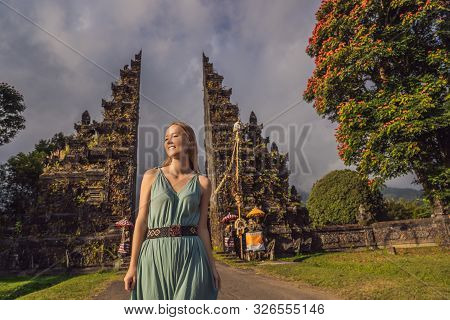 Tourist Woman Walking Through Traditional Balinese Hindu Gate Candi Bentar Close To Bedugul, Bratan 