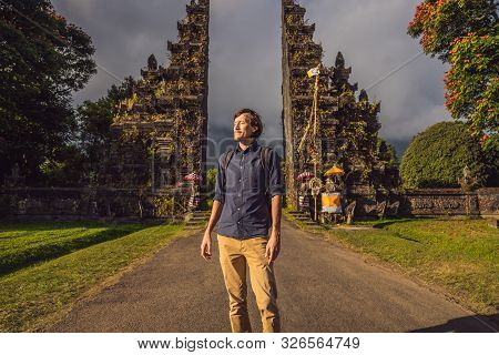 Tourist Man Walking Through Traditional Balinese Hindu Gate Candi Bentar Close To Bedugul, Bratan La