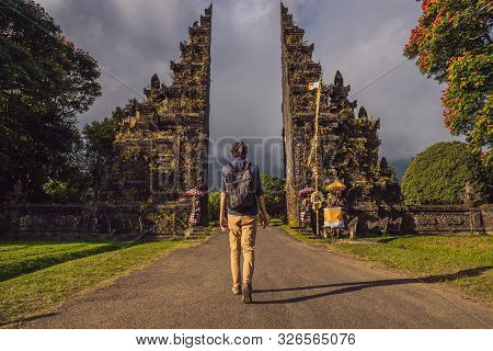 Tourist Man Walking Through Traditional Balinese Hindu Gate Candi Bentar Close To Bedugul, Bratan La