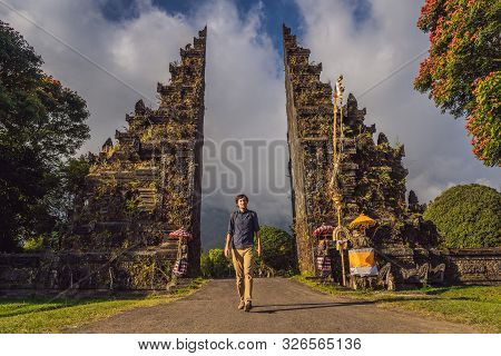 Tourist Man Walking Through Traditional Balinese Hindu Gate Candi Bentar Close To Bedugul, Bratan La
