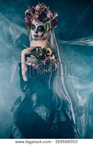 Calavera Catrina in black dress over dark background. Sugar skull makeup. Dia de los muertos. Day of The Dead. Halloween.  