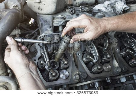 Mechanic Repairs A Truck. Adjustment Of Valves Of The Diesel Motor. Replacement Nozzles.