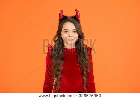 Little Devil. Little Girl Red Horns Celebrate Halloween. Carnival Concept. Small Child With Imp Styl