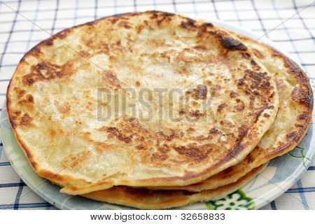 Almindelig parathas, stegt indiske flatbreads, på en plade.