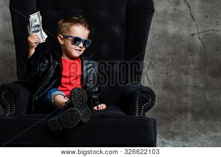 Cool Kid Millionaire In Stylish Sunglasses, Leather Jacket And Red T-shirt Is Sitting In Big Luxury 