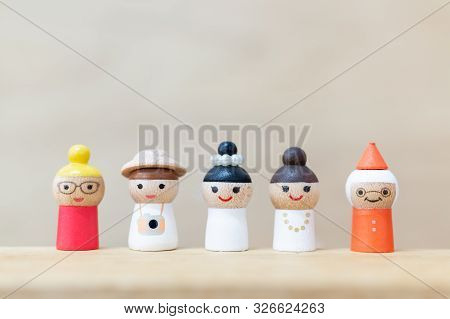 Wooden Doll With  Happy Face On Wooden Background.