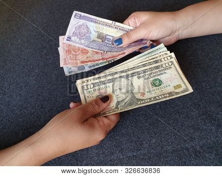 Women Hands Exchanging Honduran Banknotes And American Dollar Money