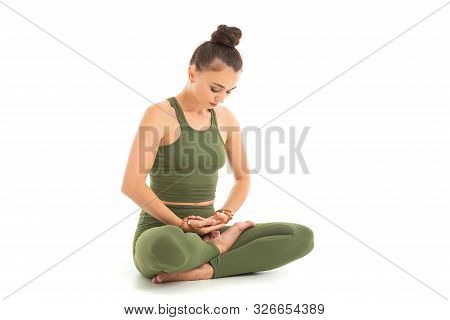 A Beautiful Young Female Gymnast With Dark Long Hair Stuffed Into A Bundle In A Green Sports Elastic