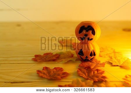 Halloween Pumpkins With Painted Faces On A Wooden Table. Halloween Background. Space For Text. Copy