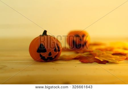 Halloween Pumpkins With Painted Faces On A Wooden Table. Halloween Background. Space For Text. Copy