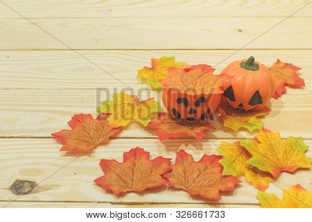 Halloween Pumpkins With Painted Faces On A Wooden Table. Halloween Background. Space For Text. Copy